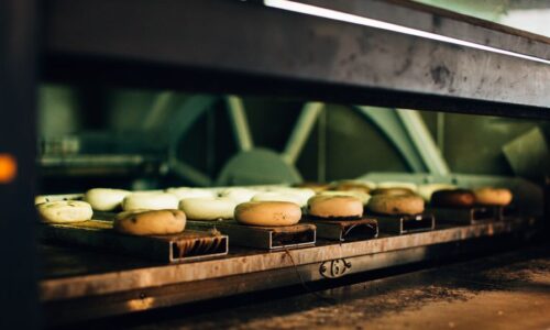 Multiple bagels baking in an industrial oven, showcasing a warm bakery ambiance. - Photo by Rachel Claire on Pexels