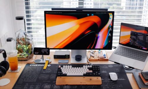 Stylish workspace with dual monitors, laptop, and gadgets on a wooden desk. - Photo by Huy Phan on Pexels