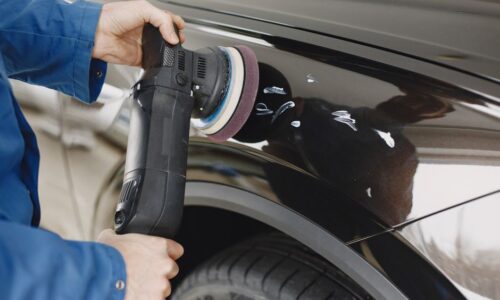 Hands using a polishing machine on a car's surface in a garage setting. - Photo by Gustavo Fring on Pexels