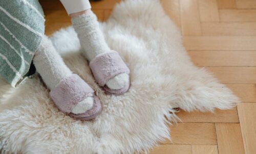 Warm and cozy feet in plush slippers resting on a soft fur rug for relaxation. - Photo by https://kaboompics.com/ on Pexels
