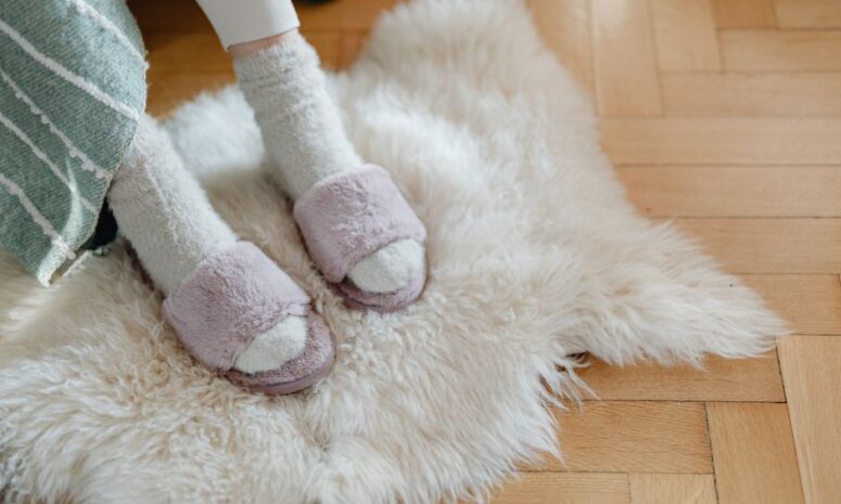 Warm and cozy feet in plush slippers resting on a soft fur rug for relaxation. - Photo by https://kaboompics.com/ on Pexels